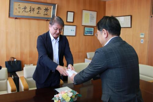 図書カードを寄付する窪田雅則会長