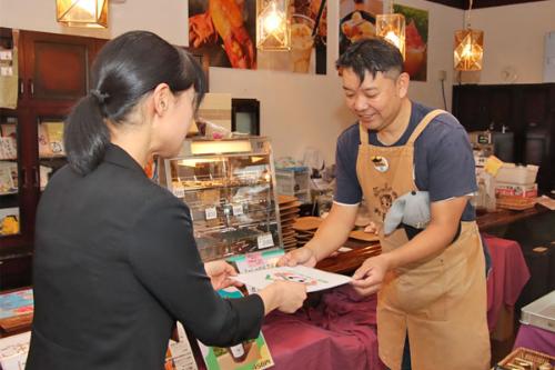登録店の掲示を受け取る吉川代表