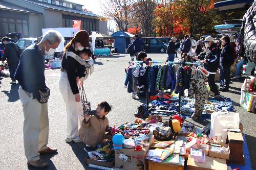 買い物を楽しむ親子づれと出店者
