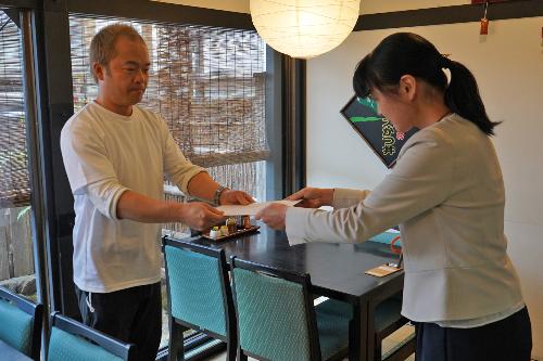 登録店の登録書を受け取る木下さん