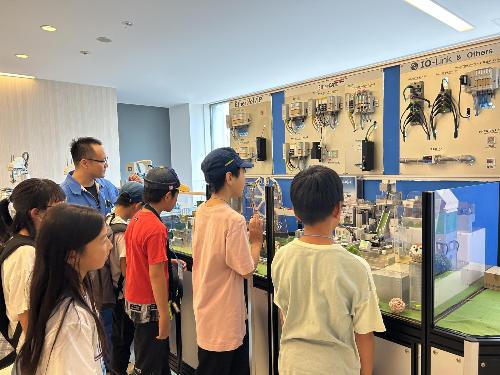 工場内で製品の展示を見学する子どもたち