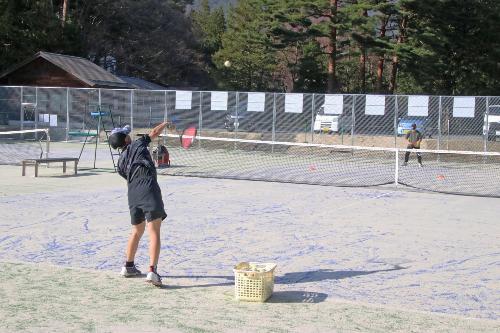 庭球場でテニスを楽しむ学生